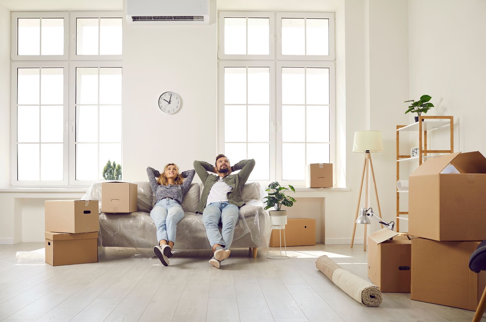 Paar entspannt auf dem Sofa der neuen Hamburger Wohnung nach dem Einzug