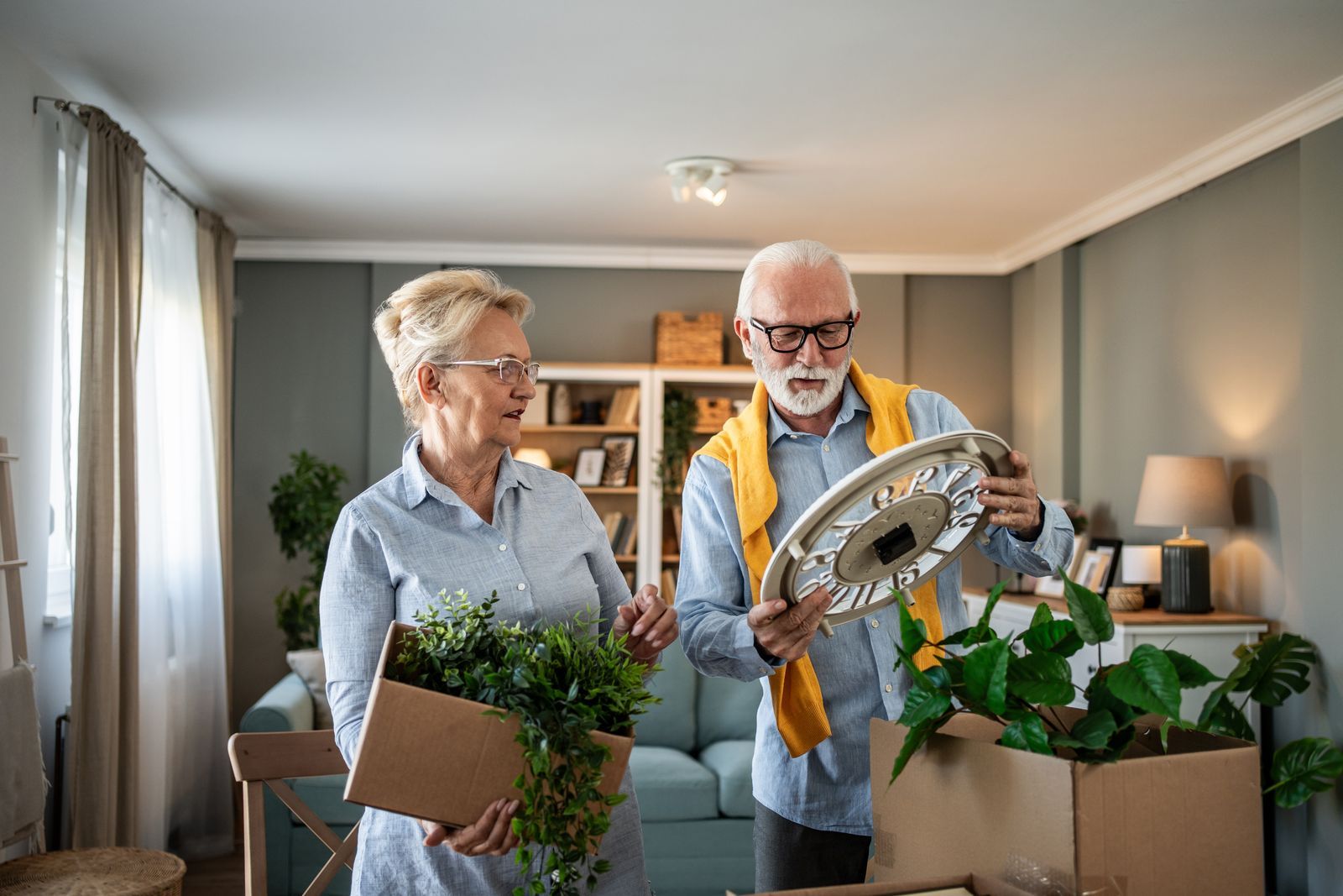 Seniorinnenpaar packt Pflanzen in einer hellen Hamburger Wohnung aus